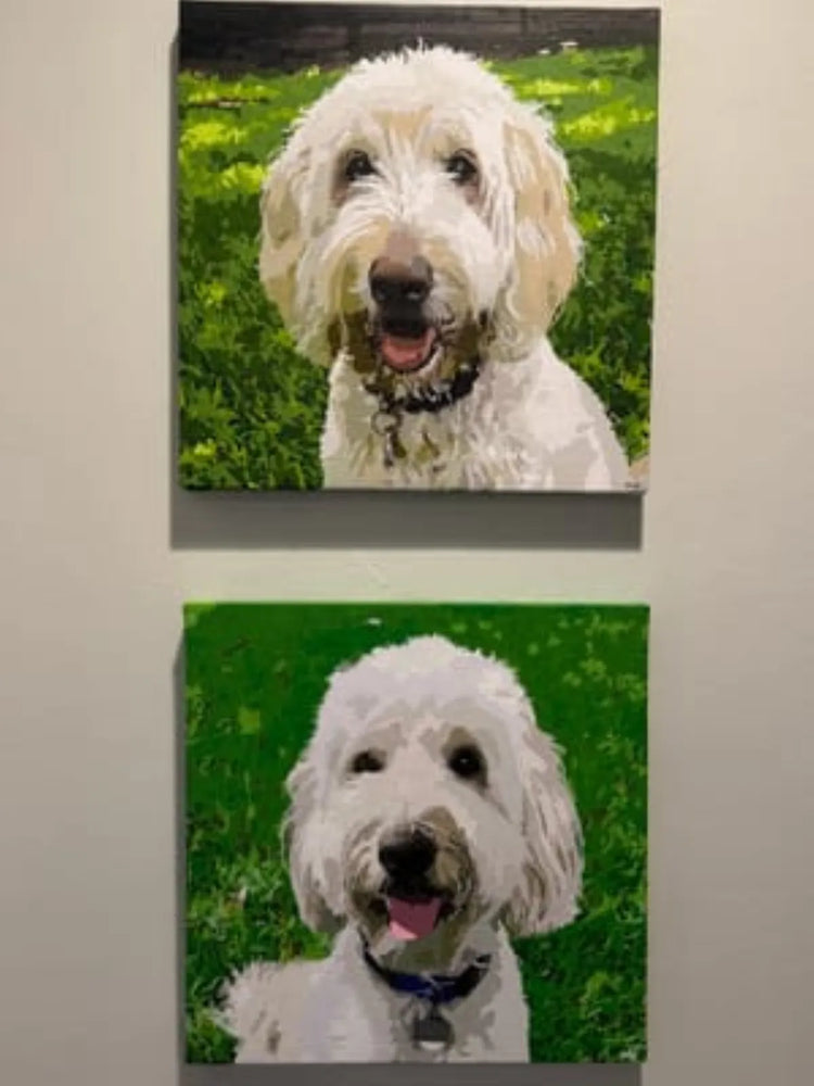 Two vertical canvas paintings of a white fluffy dog on a green grassy background, hanging on a light gray wall.